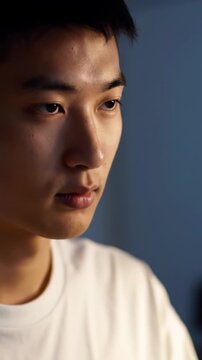 Close-up video of a young professional typing rapidly & showing intense focus, illuminated by warm chiaroscuro lighting in a modern digital workspace, concept of deep work efficiency
