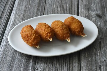 Four crab claws meat in breadcrumbs.