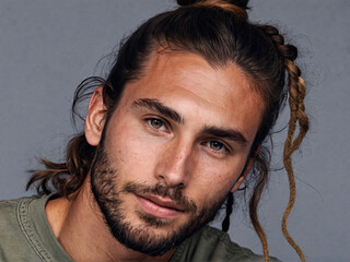 Stylish messy man bun hairstyle on Caucasian man with stubble