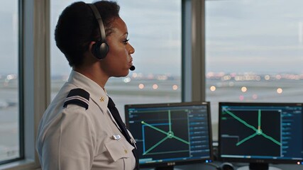Airport operations specialist supervises air traffic control at busy runway during sunset
