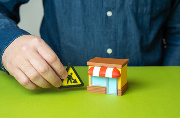 Man closes shop for repairs. Urgent work to eliminate problems in business, temporary closure, renovation, business maintenance, fixing breakdowns, restoring activity