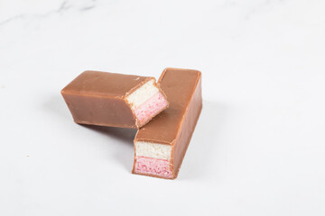 Yogurt and strawberry souffle in milk chocolate. White background. Close-up