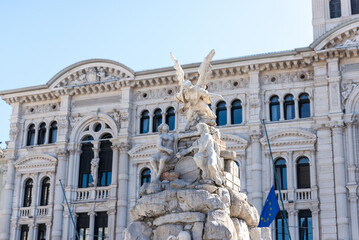 Ornate fountain with statues in Piazza Unità d’Italia, Trieste, framed by historic architecture