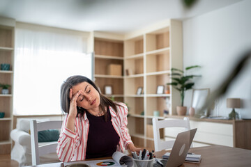 Stressed businesswoman having headache while working from home office