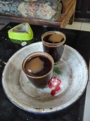 Delicious aromatic coffee served in vintage glass cups on a rustic floral plate ready to enjoy