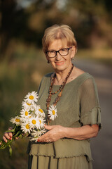 Portrait of a happy elderly woman holding a bouquet of flowers. Mother's Day