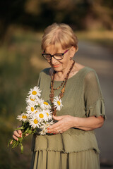 Portrait of a happy elderly woman holding a bouquet of flowers. Mother's Day