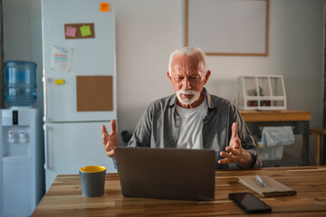 Senior freelancer working from home having a video call on his laptop