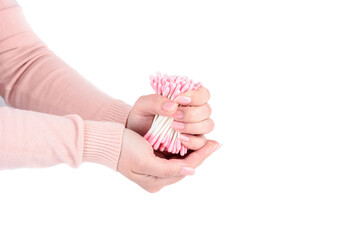 Young woman holding pink cotton swabs against white background.