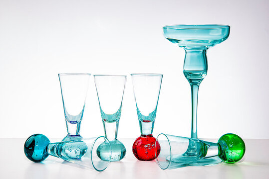 Transparent vodka glasses and one punch glass on white background, clean minimal still life, perfect for advertising barware, cocktail and beverage product photography, isolated on white