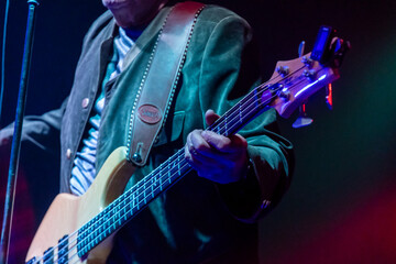 Naklejka premium Musician performs passionately with bass guitar on stage during vibrant live concert experience