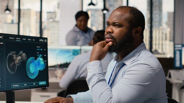 Technician uses software to plan wind farm layouts, determining optimal turbine placements. RD department employee works on CAD program to design windmills farm configurations, camera B