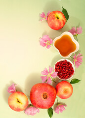 Jewish holiday Rosh Hashanah concept with apples, honey, pomegranate and flowers for greeting card, creative layout and template for Jewish New Year and Thanksgiving, autumn banner for design.