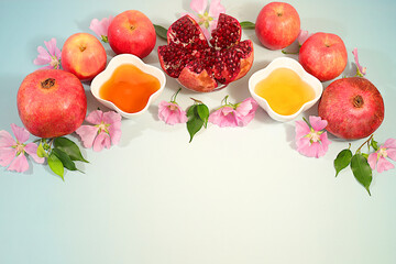Jewish holiday Rosh Hashanah concept with apples, honey, pomegranate and flowers for greeting card, creative layout and template for Jewish New Year and Thanksgiving, autumn banner for design.