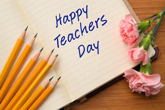 Happy Teacher's Day: Pencils, Notebook, and Pink Carnations on Wood Background - Powered by Adobe