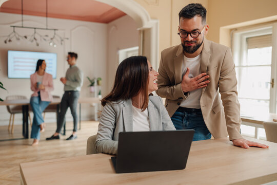 Managers expressing gratitude and appreciation to employee using laptop in the office