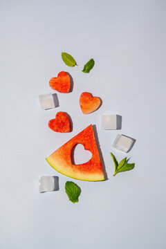 Watermelon triangle slice and heart isolated on blue background