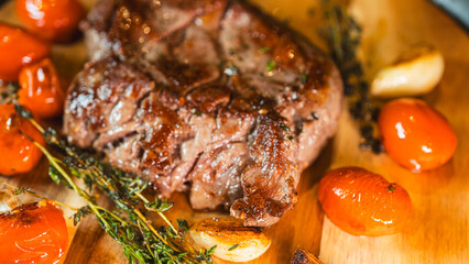 Extreme close up of a perfectly cooked medium rare ribeye steak, glistening and juicy, accompanied...