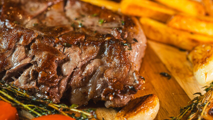 Extreme close up of a perfectly cooked medium rare ribeye steak, glistening and juicy, accompanied...