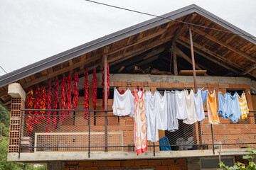 Strings of red chili peppers and laundry hanging to dry.
