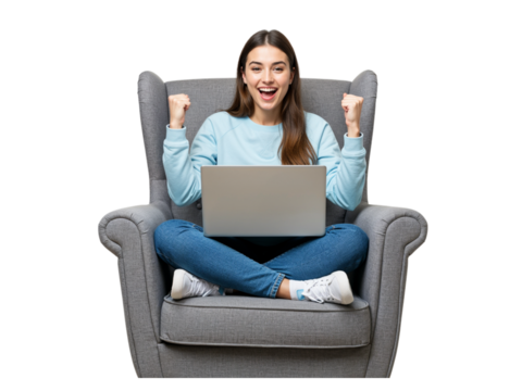Excited young woman sitting cross legged in a comfortable armchair holding a laptop and celebrating success isolated on transparent background