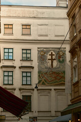 Elegant historic building in Vienna with red roof, ornate facade and fresco. Classic European architecture and cultural heritage landmark in Austria.