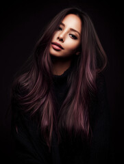 Fototapeta premium Beautiful asian model posing with long purple hair and black sweater on dark background