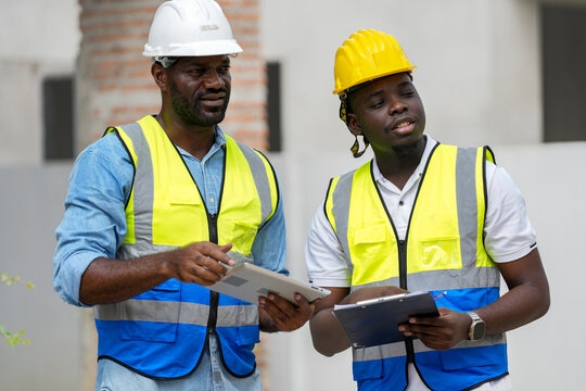 Two professional Black engineers collaborating on a building project. A skilled architect discusses plans with his colleague, representing diversity and expertise in the construction industry.