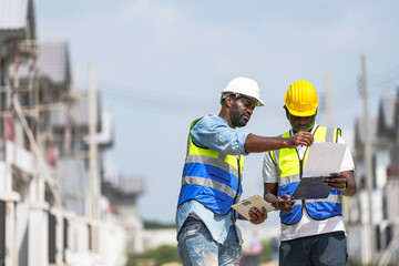 Two professional Black engineers collaborating on a building project. A skilled architect discusses plans with his colleague, representing diversity and expertise in the construction industry.
