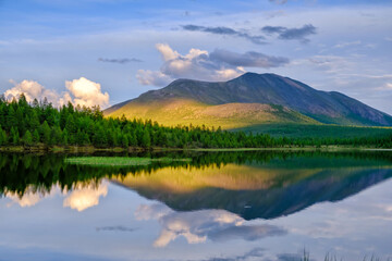 Sunset panorama of small lake with mountain reflection in Siberia, Buryatia, Russia