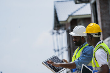 A senior electrician provides hands on training to a young apprentice on solar technology. Building...