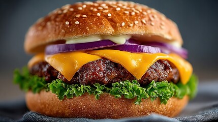 Cheeseburger with red onion and lettuce on a sesame seed bun.