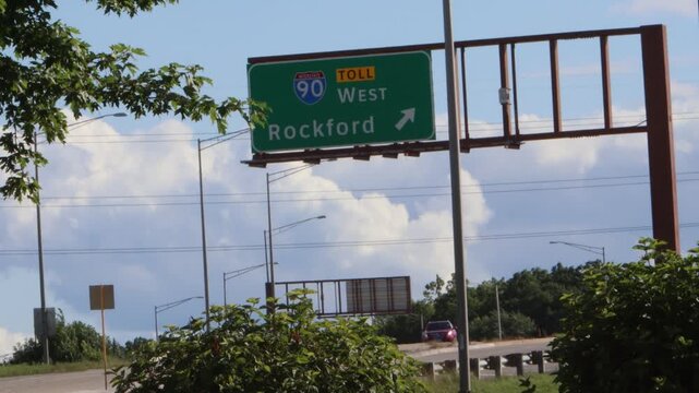 A green highway road sign on Interstate 90 heading west to Rockford, Illinois.
