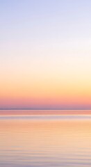 Naklejka premium Serene oceanic expanse reflecting pastel hues of dawn creating a calming ambiance