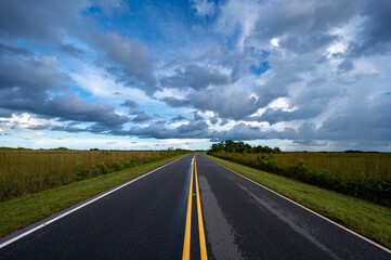 Fototapeta premium Bright summer cloudscape over Main Park Road in Everglades National Park, Florida.
