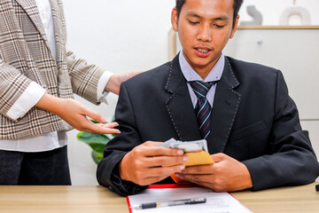 Close Up Of Bribe Accepted Man Counts Cash From Envelope While Another Indicates Contract