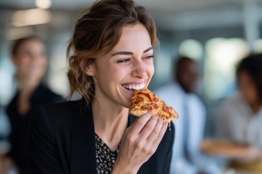 Smiling businesswoman enjoying a slice of pizza during a casual office break, showing a cheerful and relaxed moment in the workplace