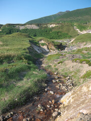 Baransky volcano morning scenery with Hot volcanic river with rising steam overgrown with green bamboo