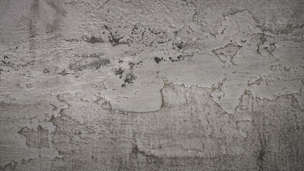 Detailed shot of weathered grey wall with dirt, stains, cracks, and peeling paint, creating an abstract grunge texture ideal for backgrounds, design projects, or old architectural surface references.