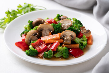 Stir fried vegetables, champignon mushroom, broccoli, bell pepper and carrot with soy sauce, Asian vegetarian food, Healthy eating