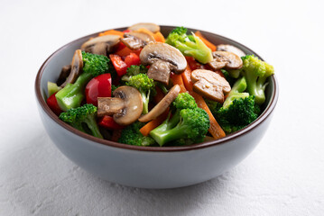 Stir fried vegetables, champignon mushroom, broccoli, bell pepper and carrot with soy sauce, Asian vegetarian food, Healthy eating