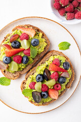Top view of avocado toast with strawberry, blueberry, raspberry and grape. Healthy eating