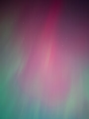 Aurora borealis in vivid green and purple shades glowing brightly in the night.