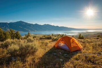Orange tent on a hillside overlooking a serene lake, bathed in golden sunlight. Mountain range in the background