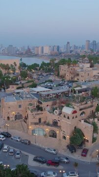 Cloes parallax drone shot of Old city of Jaffa and Jaffa port at sunset - tel aviv city at the background, Vertical video