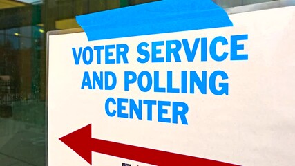 A “Voting Service Polling Center” sign with a bold arrow pointing outward, directing citizens toward their official polling place for in-person voting and civic participation on Election Day.