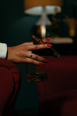 hands of a woman with a glass of whiskey