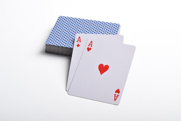 A deck of playing cards with a pair of aces on top isolated on white background