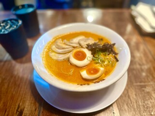 Halal ramen served with tender chicken slices resembling pork belly, topped with savory broth and fresh toppings.