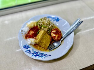 Indonesian warteg rice served with spicy chili egg, stir-fried bean sprouts, and braised tofu — authentic street food meal.